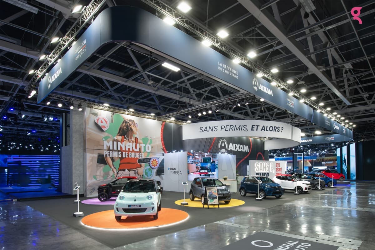 Stand Aixam au Mondial de l'Auto, voiturettes sans permis exposées sur plateaux colorés, conçu et réalisé par The Good Experience